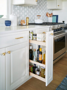 kitchen design with ivory cabinets, light blue tile, pull out shelving, annapolis md