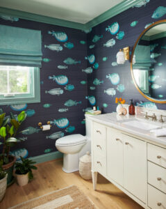 Nautical bathroom with blue fish wallpaper and custom floors and cabinets