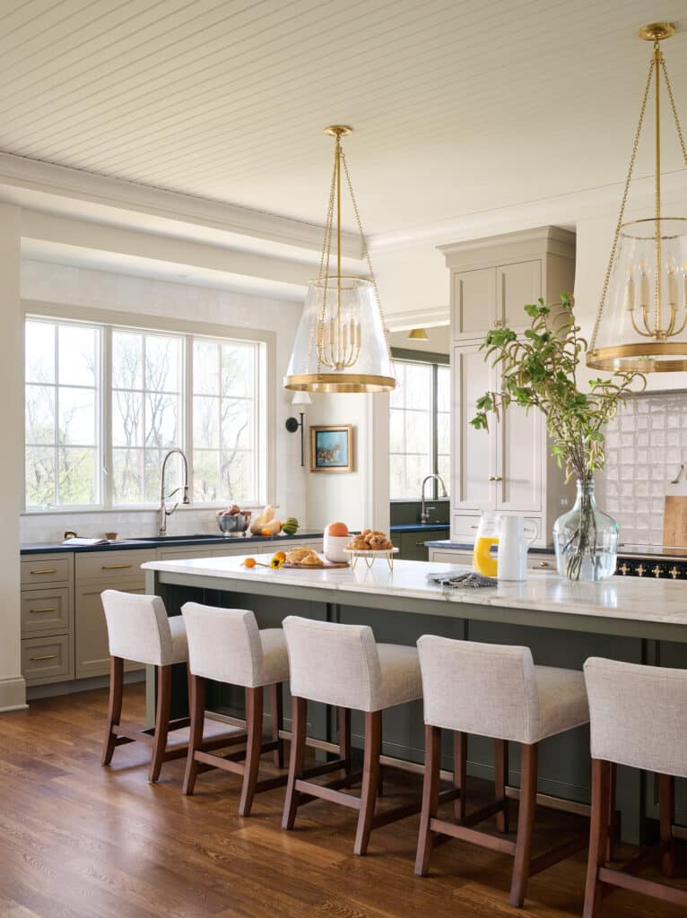 custom kitchen with green cabinet island, cream cabinets, brass hardware, lighting by visual comfort